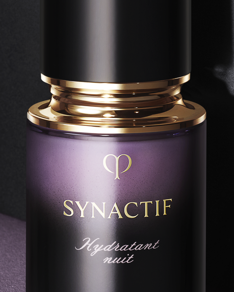 Photo of a close-up of the NIGHTTIME MOISTURIZER bottle with a glossy gold ring and central gold brand logo, in an elegantly finished container.