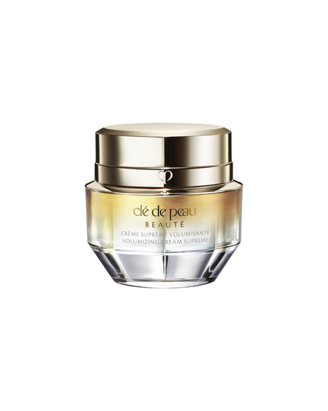 A photo of a jar of "VOLUMIZING CREAM SUPREME", featuring a gold and crystal-like design. SIZE: 50g