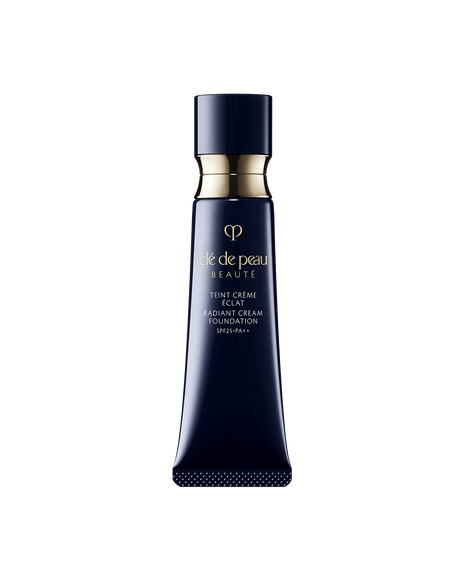 Photo of a blue black tube of "RADIANT CREAM FOUNDATION"adorned with a golden ring. SHADE: I10