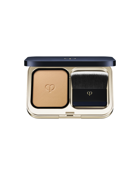 Photo of a gold compact case with powder foundation on the left and a brush on the right. SHADE: O20.