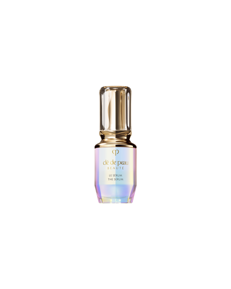 Photo of "THE SERUM" mini bottle with an iridescent finish and a rounded, translucent gold cap. Size: 30ml