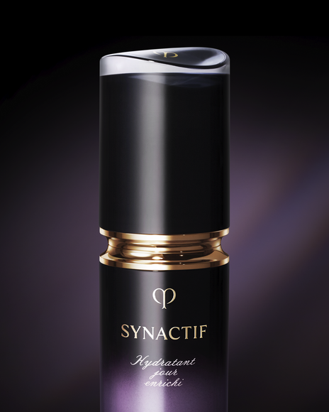 Photo of a close-up of the SYNACTIF NIGHTTIME MOISTURIZER bottle with a glossy gold ring and central gold brand logo, in an elegantly finished container.