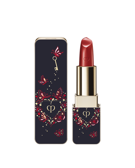 Photo of the 26 SS Collection limited-edition LIPSTICK. The navy-blue case with the Unlock Your Heart butterfly and key design is shown beside the opened lipstick. Shade: Camellia