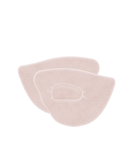 Photo of two pink eye patches. They are designed to fit around the eyes, featuring a soft texture.