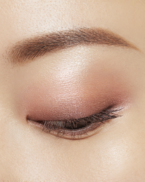 Photo of a medium skin tone model wearing EYE COLOR QUAD in 8-Warm Ocean Sunsett on the eyes.