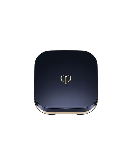 Photo of an exclusive case for "RADIANT CUSHION FOUNDATION NATURAL (REFILL)" with the lid closed. It has a rounded square shape, with a blue-black lid featuring the brand logo in the center.