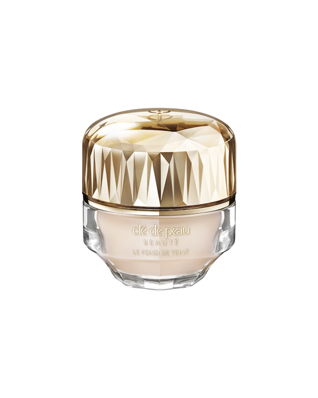 Photo of a jar of &ldquo;THE FOUNDATION,&rdquo; featuring an impressive multi-faceted gold cap and a substantial, luxurious glass bottle. SHADE: I10