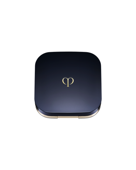 Photo of an exclusive case for "RADIANT CUSHION FOUNDATION DEWY" with the lid closed. It has a rounded square shape, with a blue-black lid featuring the brand logo in the center.