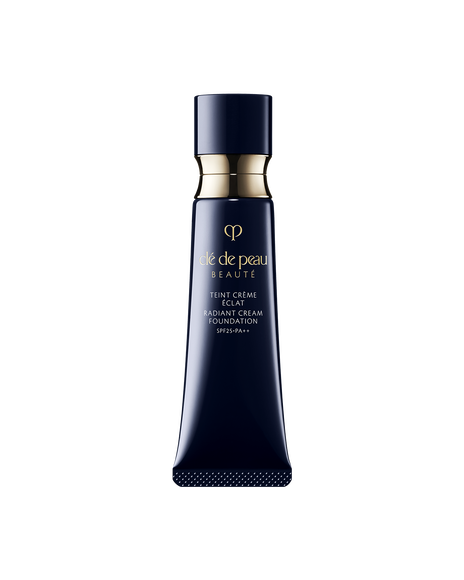 Photo of a blue black tube of "RADIANT CREAM FOUNDATION"adorned with a golden ring. SHADE: O20