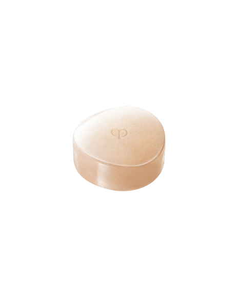 Photo of the luxurious Cl&eacute; de Peau Beaut&eacute; SYNACTIF SOAP Refill. An elegant, round purifying soap in a warm peach hue is presented within a sophisticated, clear case. The brand's logo is delicately embossed on the surface of the soap and on the lid of its case. SIZE : 100g Refill