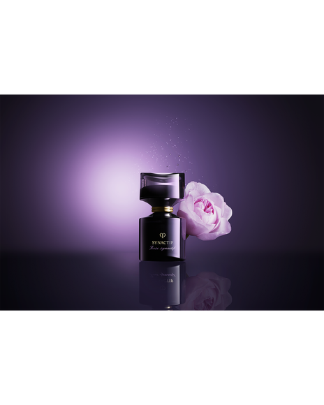 Photo of  a pale pink rose placed beside  black ROSE SYNACTIF bottle.