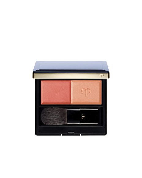 Photo of the "POWDER BLUSH DUO (REFILL)" set in a square compact with a navy lid and gold trim, containing two blush shades and a brush. The left side holds the matte powder, and the right side holds the pearly powder embossed with the logo.Shade: 104.