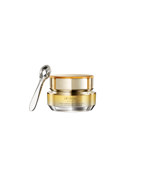Photo of a jar of "EYE CONTOUR CREAM SUPREME" with a gold-to-silver gradient and a faceted silver spatula. SIZE: 6g.