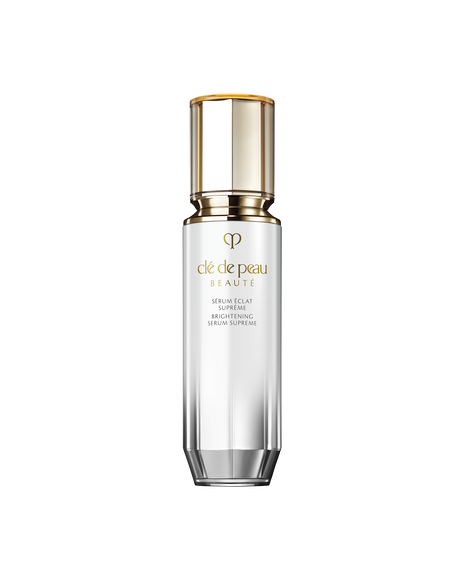Photo of BRIGHTENING SERUM SUPREME, a brightening serum in a cylindrical bottle with a pearl-white to silver gradient, a gold dispenser, and a clear cap. SIZE: 40mL