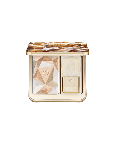 Photo of  &ldquo;THE LUMINIZING FACE ENHANCER,&rdquo; a face powder set that includes a highlighter powder designed with geometric patterns in gold and platinum gold, along with a gold brush. Shade: Shade: 202-Golden Galaxy.