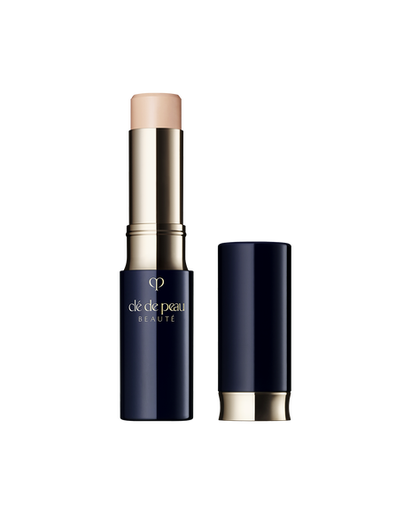 Photo of "CONCEALER," a stick-type product in a glossy blue-black and gold case. The brand logo is engraved in the center of the packaging. SHADE: Beige.