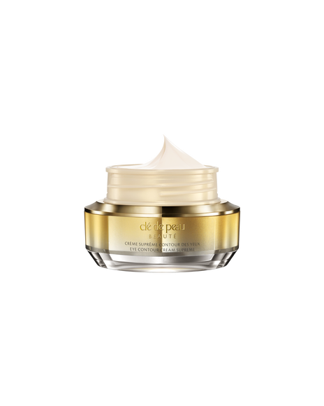 Photo of "EYE CONTOUR CREAM SUPREME" with its lid open, revealing a fluffy, smooth cream inside a gold-and-silver jar.
