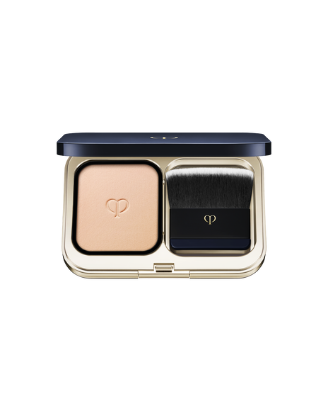 Photo of a gold compact case with powder foundation on the left and a brush on the right. SHADE: B00.