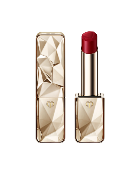 Photo of "THE PRECIOUS LIPSTICK", featuring a sparkling gold case and cap that reflects light. SHADE: Scarlet Diamond.