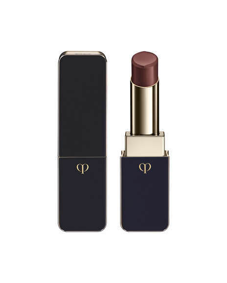 Photo of LIPSTICK SHINE with the bullet twisted up; the body combines blue‑black and gold sides with a gold emblem. SHADE: Cocoa Dahlia.