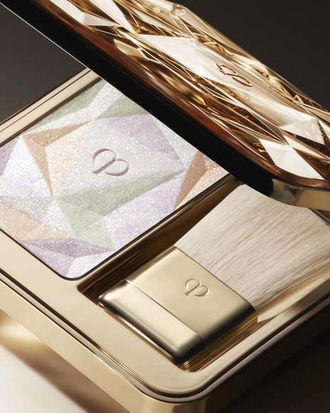 Close-up photo of the highlighting powder in its luxurious gold case.
