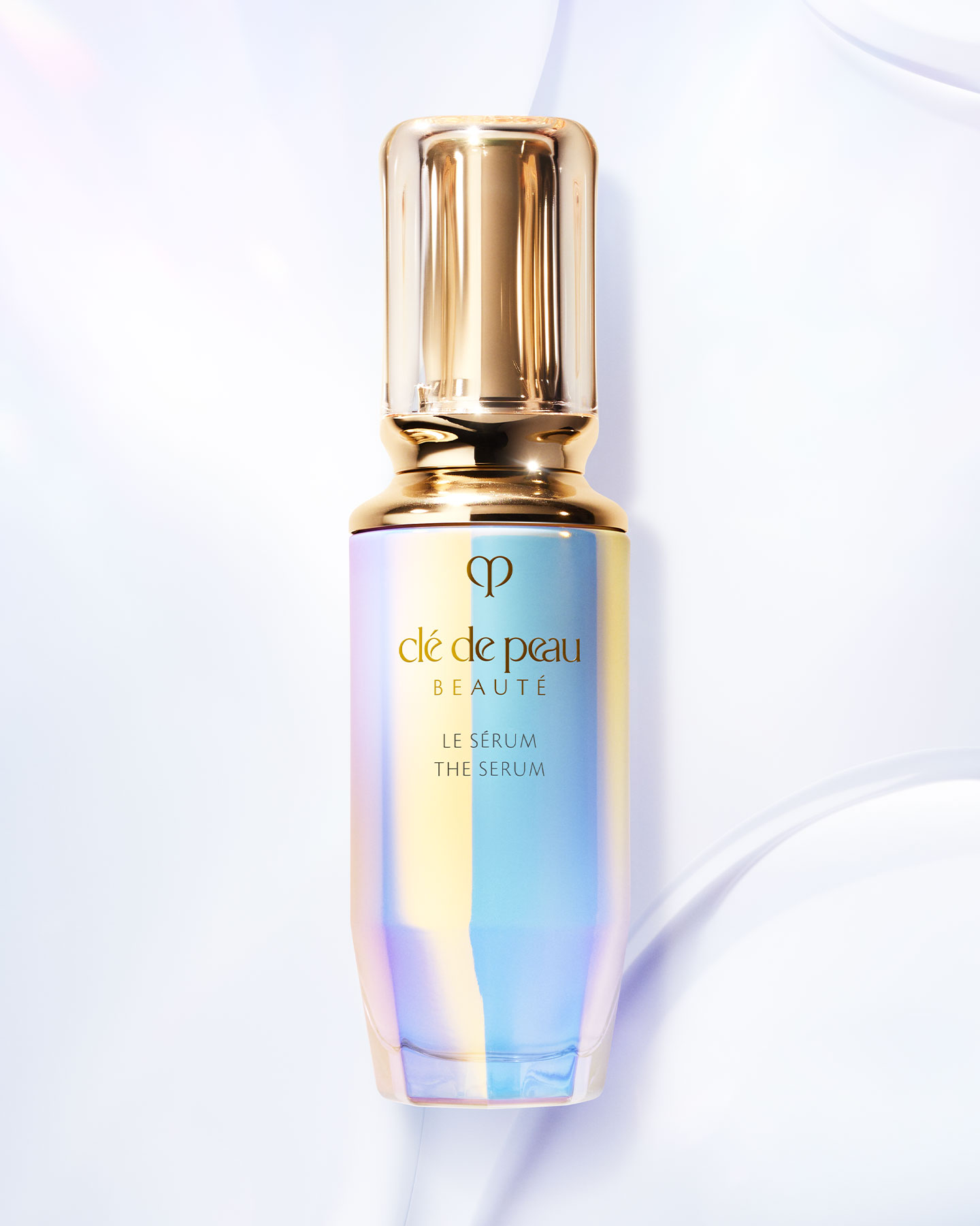 Photo of The Serum bottle with an iridescent finish and a rounded, translucent gold cap.