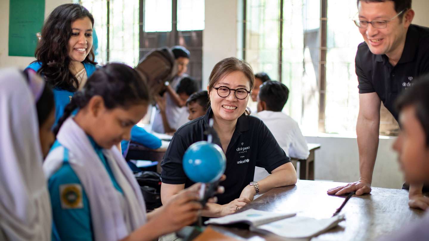 相片顯示Cl&eacute; de Peau Beaut&eacute;代表團在孟加拉參觀課堂時與學生互動交流。