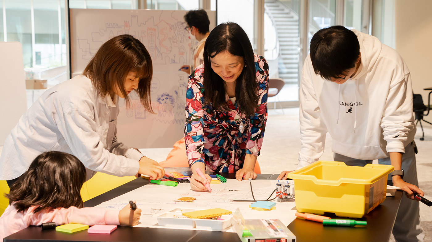 Photo of four people gathered around a table, collaborating on a project.