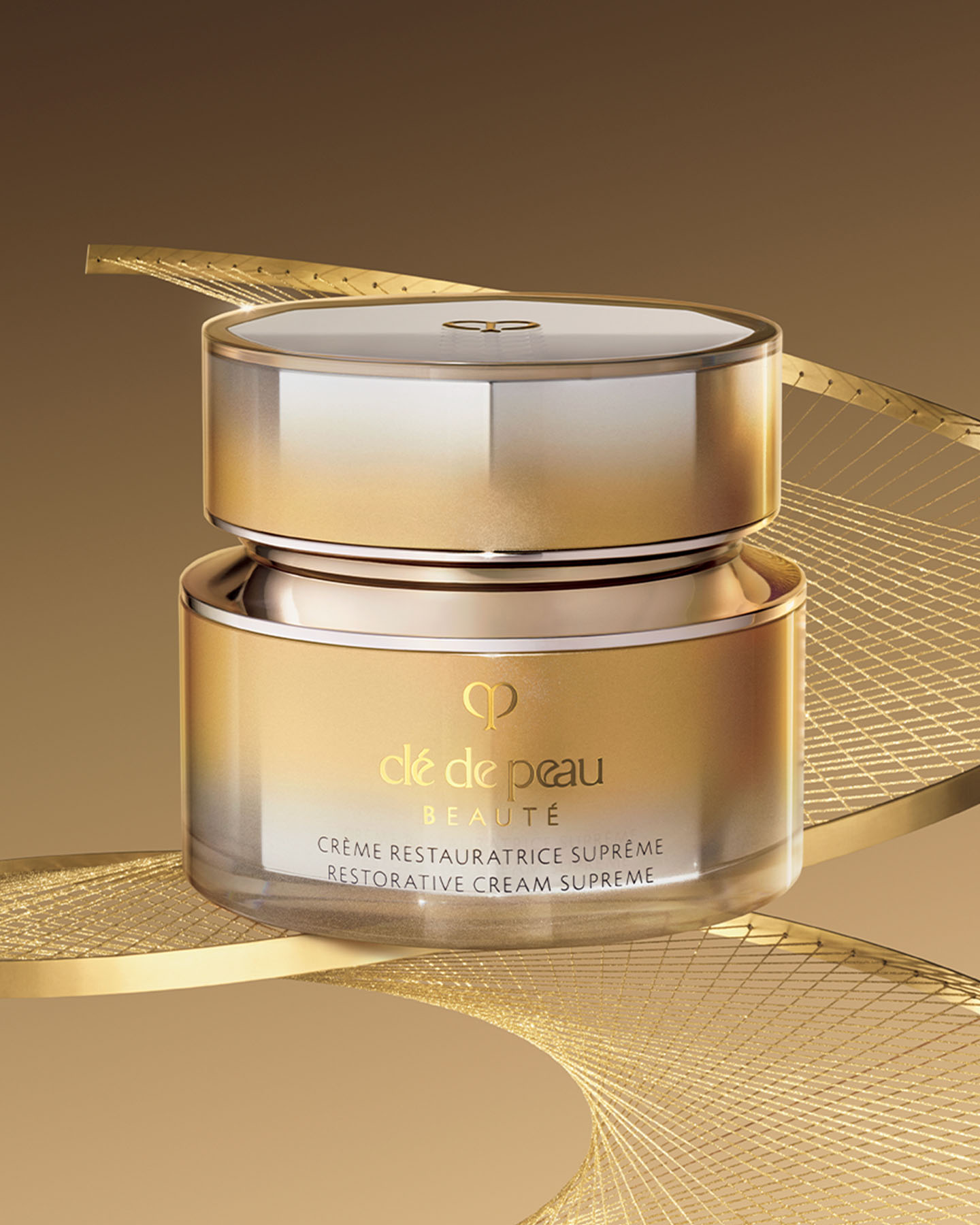Photo of a FIRMING SERUM SUPREME bottle with a gradient design transitioning from gold at the top to silver at the bottom.