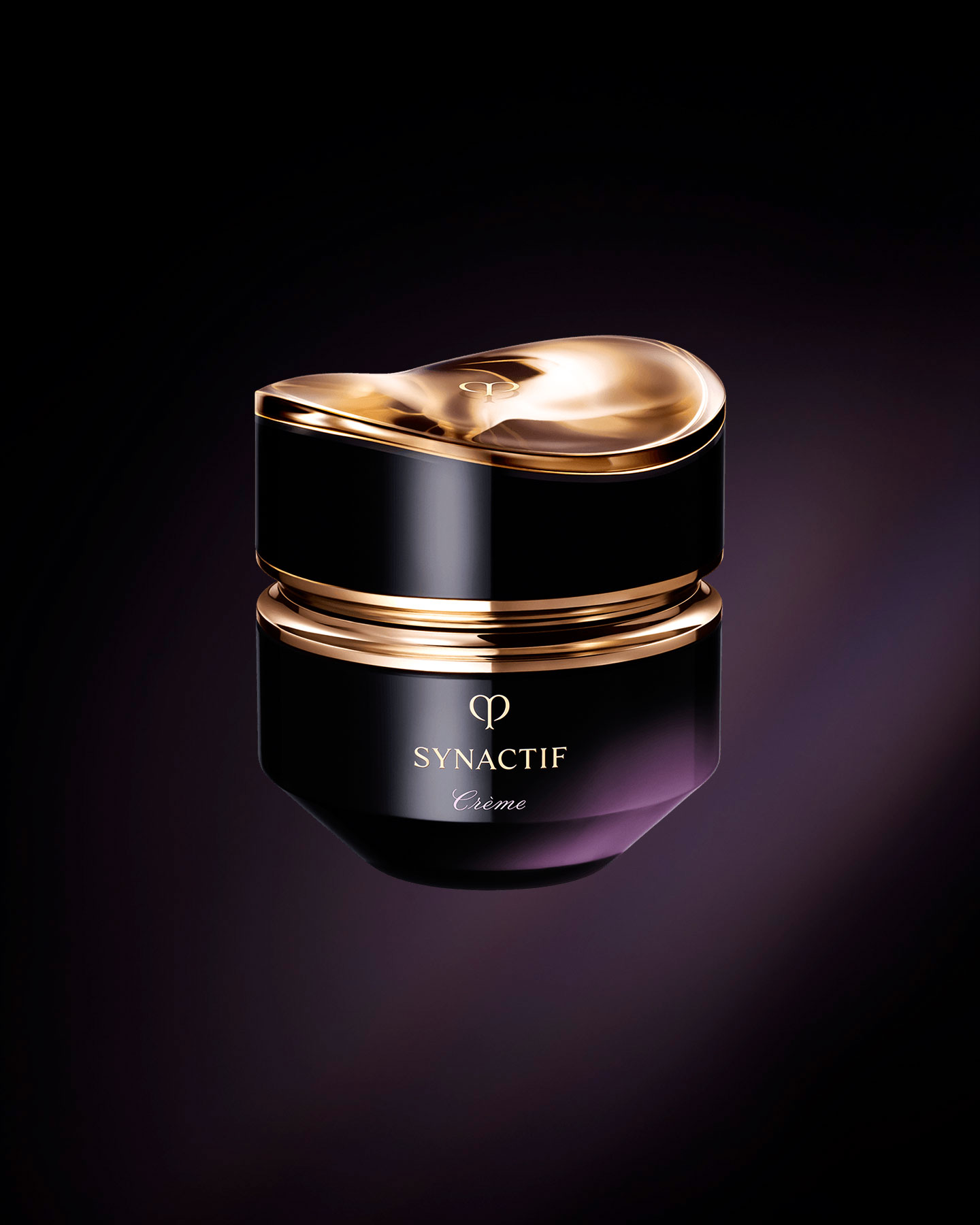 Photo of the Cl&eacute; de Peau Beaut&eacute; Synactif CREAM. The cream is presented in a jar with a black-to-purple gradient. The lid features a sculptural gold design, and the 'SYNACTIF' logo is elegantly displayed on the front.