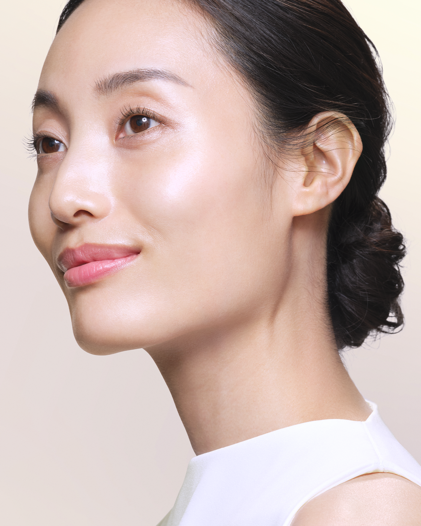 Photo showing the after result of using Skin Beauty Enhancer. A woman&rsquo;s side profile looks slightly upward with smooth, luminous skin reflecting a clear glow on her cheekbone and jawline.